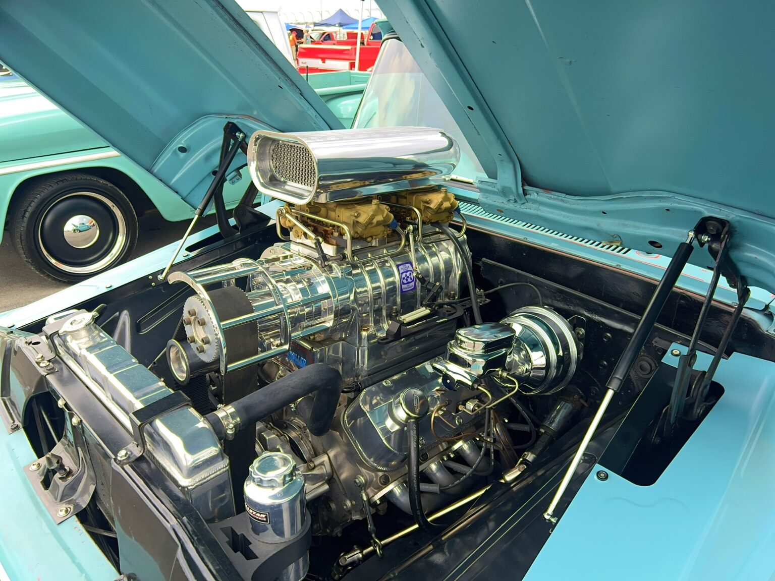 Polished supercharged engine in a turquoise Chevrolet truck